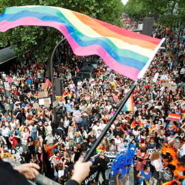 Una persona ondea una bandera del arco iris sobre una multitud de participantes de la tradicional marcha del Orgullo LGBTQ, en medio del brote de la enfermedad del coronavirus (COVID-19), en París, Francia, el 26 de junio de 2021.