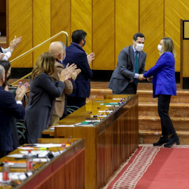 25/11/2021.- El presidente de la Junta, Juanma Moreno (2d), felicita a la consejera de Fomento, Marifrán Carazo (d), en el Pleno del Parlamento de Andalucía en Sevilla que ha aprobado este jueves 25 de noviembre la Ley del Suelo.