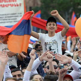 Dos jóvenes armenios portando una bandera durante una concentración en Yereván, Armenia. / Reuters