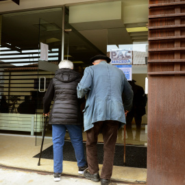 15/12/21. Una pareja de personas mayores se ayuda mutuamente en la puerta de un centro de salud de Ourense, a 25 de octubre de 2021.