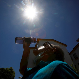 Un hombre bebe agua para aliviar las altas temperaturas registradas en Córdoba.