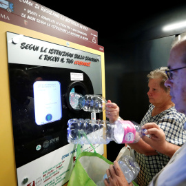 Dos vecinos de Roma haciendo uso de esta iniciativa que une reciclaje y transporte público. / Reuters