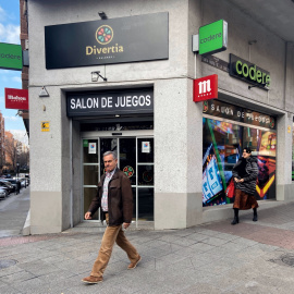 Dos personas pasan junto a un salón de juegos de Madrid.