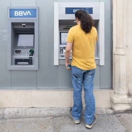 Imagen de archivo de un hombre realizando operaciones financieras en un cajero de BBVA.