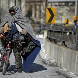 Un ciudadano de Nueva York sin hogar caminando por el puente de Brooklyn. / Reuters