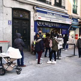 Varias personas hacen cola ante la administración de lotería Doña Manolita, en Madrid, a 5 de enero de 2021