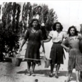 Las mujeres de Lanaja cogen agua de los barreños para hacerlo llegar a casa