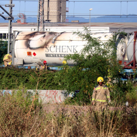 Els Bombers al costat del vagó del tren de mercaderies que s'ha incendiat a Girona