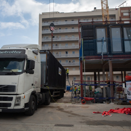 01/08/2024 Operarios descargan contenedores marítimos para construir el edificio de alojamientos Aprop de las Glòries, en Barcelona. Foto de archivo.