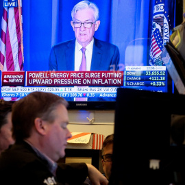 Un monitor de televisión en el patio de negociación de la Bolsa de Nueva York (NYSE, en sus siglas en inglés), en Wall Street, ofrece la comparecencia del presidente de la Reserva Federal, Jerome Powell, tras la reunión en la que se ha acordado la pri