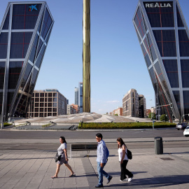 Varias personas pasan por la madrileña Plaza de Castilla, en plena cuarta ola de calor. REUTERS/Ana Beltran