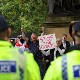 Agentes de la policía británica frente a un grupo de manifestantes ultras contra los migrantes, en la localidad de Mánchester, durante la ola de violencia racista en el Reino Unido. REUTERS/Manon Cruz