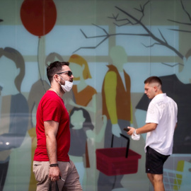 Dos hombres caminan con la mascarilla quitada este sábado en San Sebastián.