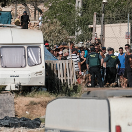 Los habitantes del poblado de Can Roba acordonados por la Guardia Civil en el momento del desalojo, en Ibiza, a 31 de julio de 2024.