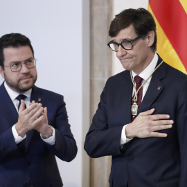 El presidente electo de la Generalitat, Salvador Illa (d), y el expresidente, Pere Aragones, durante el acto de toma posesión de Illa este sábado en Barcelona.