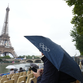 26 de julio de 2024. Un turista bajo un paraguas en la ceremonia de inauguración de los Juegos Olímpicos.