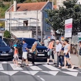 Vecinos de O Hío (Pontevedra) cortan el tráfico cruzando la calle de forma ininterrumpida.