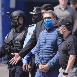 22/04/2022 - El expresidente hondureño Juan Orlando Hernández es dirigido a la aeronave que lo llevará extraditado a los Estados Unidos hoy, en la base aérea Hernán Acosta de Tegucigalpa (Honduras).