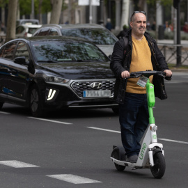 Un hombre montado en un patinete eléctrico en Madrid.