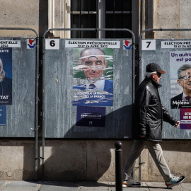 4/04/2022-Un hombre pasa junto a carteles que muestran a los candidatos presidenciales franceses en París, Francia, el lunes 4 de abril