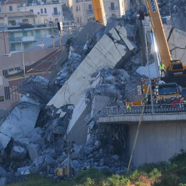 Una grúa trabaja en las labores de búsqueda de víctimas y retirada de los escombros del puente que el martes se desplomó en Génova. - EFE