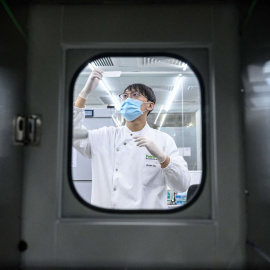 En esta foto tomada el 5 de junio de 2020, un empleado manipula una vacuna en un laboratorio de Hong Kong.