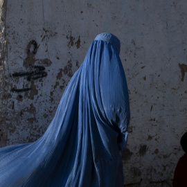 Una mujer afgana vestida con burka camina con un niño en Kabul el 28 de abril de 2022.