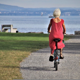 Una mujer pasea en bici camino de la playa.