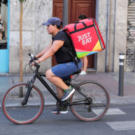 Fotografía de un repartidor de la empresa de reparto Just Eat transitando en bicicleta por una calle del centro de Madrid, a 1 de agosto de 2019.