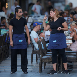 Dos camareros charlan en una terraza de un restaurante de la localidad malagueña de Ronda. REUTERS/Jon Nazca