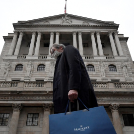 Un hombre con mascarilla pasa por delante del edificio de la sede del Banco de Inglaterra (BoE, en sus siglas en inglés), en la City de Londres. REUTERS/Toby Melville