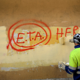 Un empleado municipal tapa una pintada que pone 'ETA, el pueblo está contigo', en Gernica, en octubre de 2011, al día siguiente del anunio de la organización terrorista del cese de su actividad armada. REUTERS/Vincent West