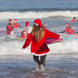 Un año más los Papá Noeles surferos se han dado cita en la playa de Patos en Nigrán para cabalgar las olas en un día primaveral, que hacía tiempo que no se veía en Galicia . EFE / Salvador Sas