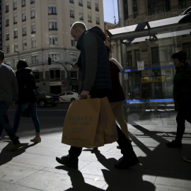 Varias personas con las bolsas de sus compras por el centro de Madrid. REUTERS/Andrea Comas