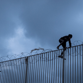 Un menor extranjero salta la alambrada del puerto de Ceuta, donde vive tras escapar del masificado centro de acogida de la ciudad con el objetivo del llegar a la península como polizón en un ferry.- PEDRO ARMESTRE /SAVE THE CHILDREN