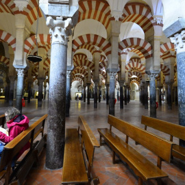 Una turista leen sentada en la Mezquita de Córdoba. AFP/Jorge Guerrero