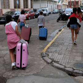 Varias de las menores marroquíes devueltas de Palencia a Melilla cargan con sus maletas en la ciudad autónoma.- JOSÉ PALAZÓN/PRODEIN