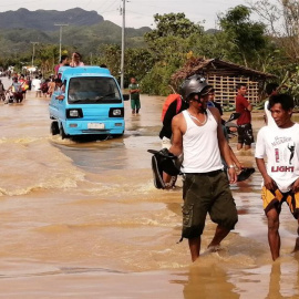 Ormoc (Filipinas), 25/12/2019.- Gente anda por el agua en una carretera inundada el día de Navidad en la ciudad de Ormoc, Filipinas, azotada por el tifón Phanfone, el 25 de diciembre de 2019. El tifón Phanfone (conocido localmente como Ursula) tocó ti