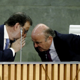 Fotografía de septiembre de 2016, del entonces presidente del Gobierno en funciones, Mariano Rajoy, con el ministro de Economía en funciones, Luis de Guindos (actualmente vicepresidente del BCE), en un acto en Madrid. EFE