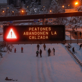 Varios ciudadanos caminan y juegan con la nieve en mitad de la M-30 de Madrid.