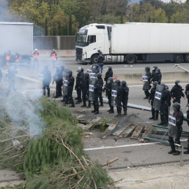 13/11/2019 - Mossos d'Esquadra davant d'una barricada d'arbres fumejant col·locada per tallar l'AP-7 el novembre de 2019.