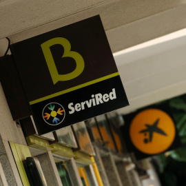 Los logos de Bankia y de Caixabank en sendas sucursales en Barcelona. REUTERS/Albert Gea