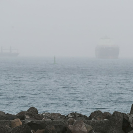 Un joven observa dos barcos que se adivinan en la bahía de Las Palmas de Gran Canaria. EFE/Elvira Urquijo A.