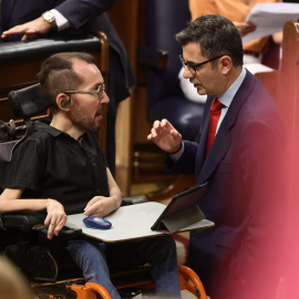 El portavoz de Unidas Podemos en el Congreso, Pablo Echenique (i), y el ministro de Presidencia, Félix Bolaños, conversan en una sesión de control, en el Congreso de los Diputados. E.P./Eduardo Parra