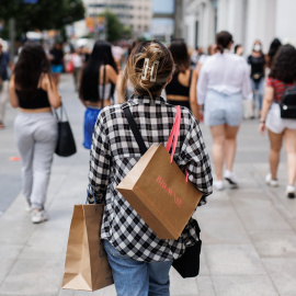 21/06/2022-Una mujer pasea con bolsas por la Gran Vía, a 21 de junio, en Madrid