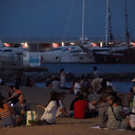 Un grup de gent sopa a la platja del Somorrostro de Barcelona a la revetlla de Sant Joan.