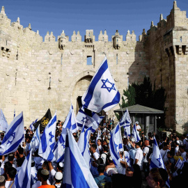 Los israelíes bailan y cantan mientras sostienen banderas nacionales israelíes junto a la puerta de Damasco en la ciudad vieja de Jerusalén.