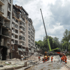 Los trabajadores comunales limpian los escombros frente a un edificio residencial dañado luego de los ataques aéreos rusos en el distrito Shevchenkivskiy de Kyiv (Kiev), Ucrania, el 26 de junio de 2022.