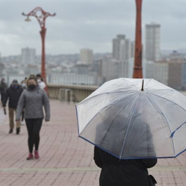 Una persona pasea con paraguas en el Paseo Marítimo, el mismo día del paso de la borrasca Justine convertida en ciclogénesis explosiva en A Coruña, Galicia.