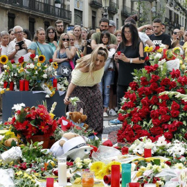 Grupo de personas depositan flores en el mosaico de Miró en Las Ramblas en recuerdo de las victimas de los atentados del 17-A. - EFE